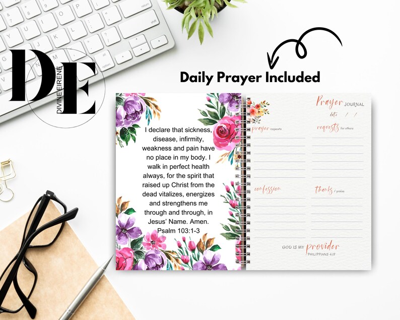 May include: A pink and purple floral design journal with a daily prayer included. The journal has a spiral binding and a section for prayer requests, confessions, and thanks. The text on the cover reads "God is my provider, Philippians 4:19".