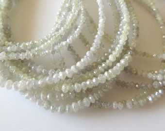 May include: A strand of white diamond beads, with a rough, faceted finish. The beads are small and uniform in size, and they are strung on a thin wire.