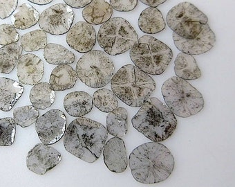 May include: A collection of 30 raw, unpolished, gray diamonds. The diamonds are round and have a rough, natural texture.