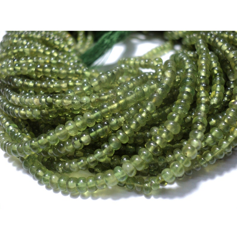 Peut inclure: Un brin de perles de p&eacute;ridot vert. Les perles sont rondes et ont une finition lisse et polie.