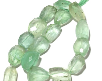 May include: A strand of light green gemstone beads, each bead is faceted and has a slightly irregular shape.