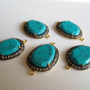 May include: Five turquoise gemstone connector pieces with gold and silver accents. Each piece has a turquoise stone surrounded by a silver bezel and a gold rim. The stones are oval shaped and have a mottled pattern.