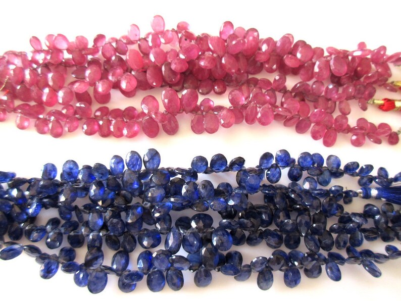 May include: Two strands of gemstone beads. One strand is made of pink faceted beads, the other is made of blue faceted beads.