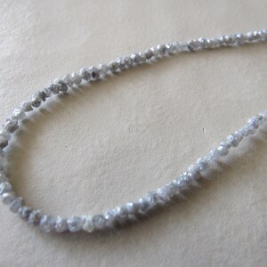 May include: A strand of grey rough diamonds strung together to form a necklace.