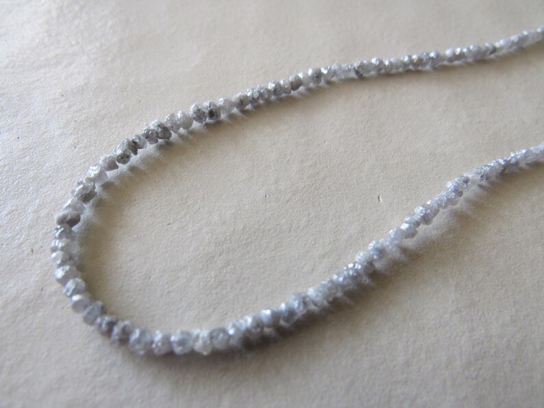 May include: A strand of grey rough diamonds strung together to form a necklace.
