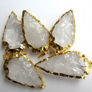 May include: Five clear quartz arrowhead pendants with gold-plated edges. The pendants have a raw, natural look and are perfect for jewelry making.