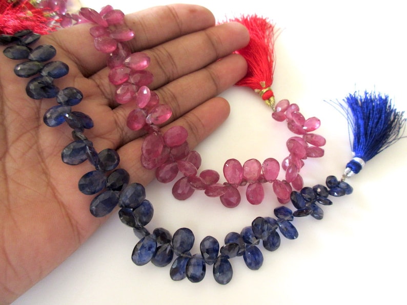 May include: A strand of blue gemstone beads and a strand of pink gemstone beads, both with tassel ends.