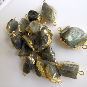 May include: A group of 14 raw labradorite gemstone beads with gold-plated accents. Each bead has two gold-plated loops for attaching to jewelry.