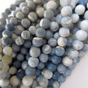 May include: A strand of blue and white agate beads. The beads are round and have a smooth, polished finish. They are perfect for making jewelry or other crafts.