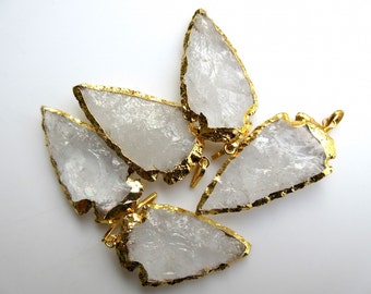 May include: Four clear quartz arrowhead pendants with gold-plated edges. The pendants have a raw, natural look and are perfect for jewelry making.