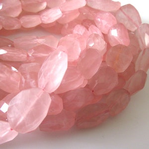May include: A strand of pink rose quartz beads, each bead is faceted and oval shaped.