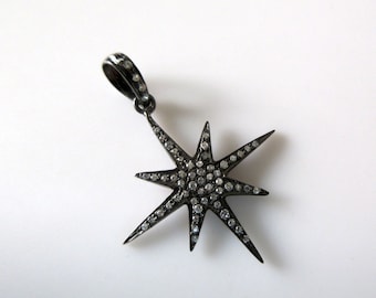 May include: A black oxidized silver pendant in the shape of a six-pointed star with a pave setting of small white diamonds.