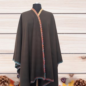 Front view of handmade baby alpaca ruana poncho featuring vibrant crochet edging and elegant draped silhouette.