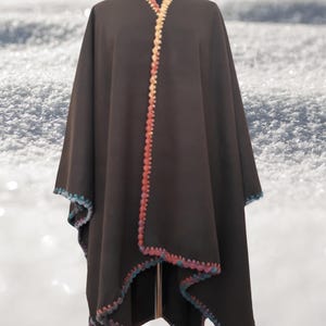 Front view of handmade baby alpaca ruana poncho featuring vibrant crochet edging and elegant draped silhouette.
