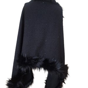 Black heavy tweed evening wrap with Racoon fur collar, styled in an asymmetrical drape for a dramatic and sophisticated winter look
