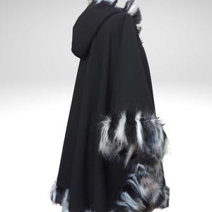 May include: A black hooded cape with faux fur trim. The cape features a hood and is trimmed with black, white, and gray faux fur along the hood, cuffs, and hemline. The cape is made of a soft, flowing fabric.