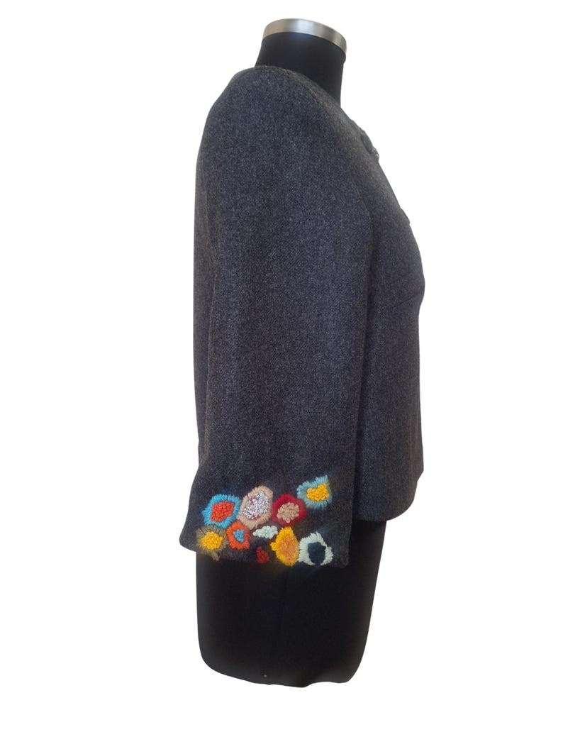 May include: A gray wool jacket with colorful embroidered flowers on the cuff.