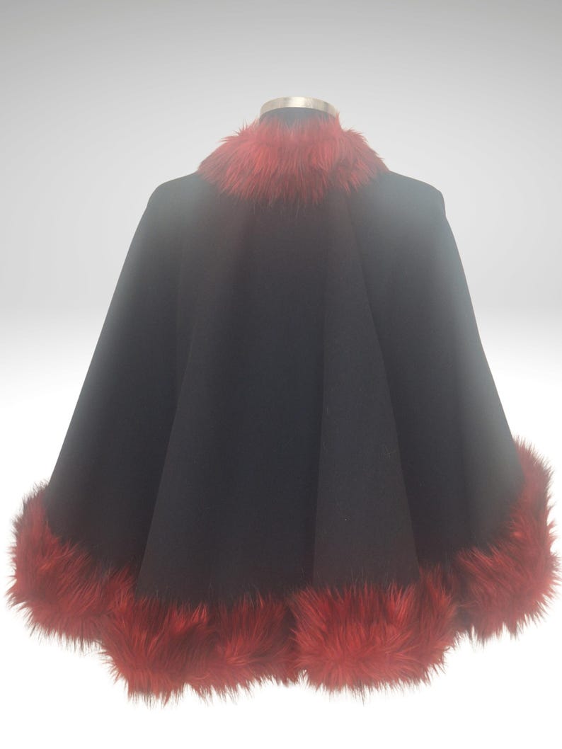 Black Alpaca half cape with red fur is displayed on a mannequin against a white background. The cape is a statement piece