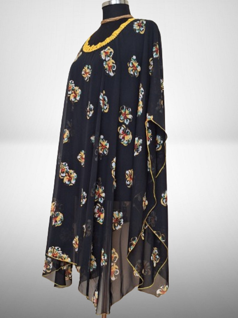 Puede incluir: Una t&uacute;nica negra transparente con estampado floral amarillo y cuello de ganchillo amarillo.
