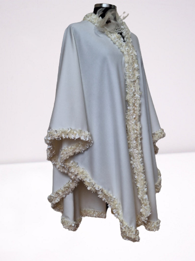 This ivory cashmere cape is a timeless luxury piece, designed as an elegant winter wrap, evening cape, or refined bridal accessory