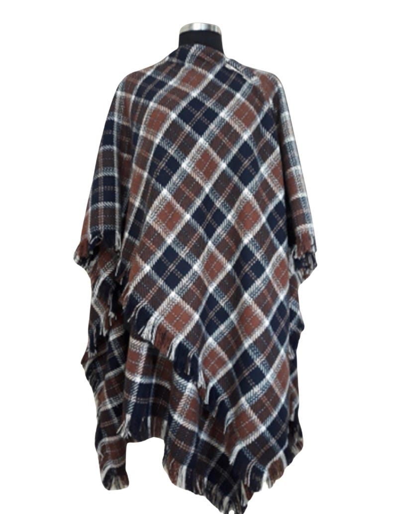 A Tan, white, and blue plaid poncho with fringe 
100% Lambswool