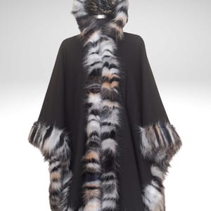 Front view of a handmade black cashmere winter cape with richly textured  fur trim in natural mixed tones, showing its elegant drape and thick, warm edging.