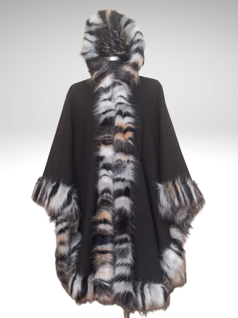 Front view of a handmade black cashmere winter cape with richly textured  fur trim in natural mixed tones, showing its elegant drape and thick, warm edging.