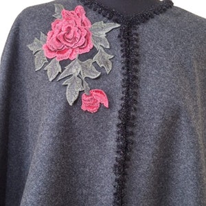 May include: Gray wool poncho with a black crocheted trim and a pink embroidered rose.