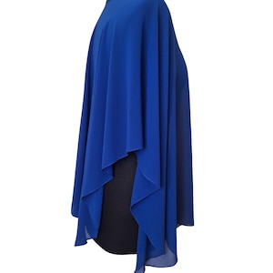 May include: A royal blue cape-style garment with a flowing design. The cape is draped over a black form, showcasing its shape and texture. The neckline appears to have a subtle beaded detail.