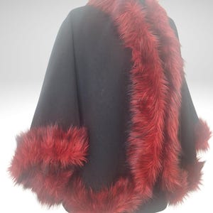 A Right  view of black alpaca short cape with red fur trim on a black mannequin