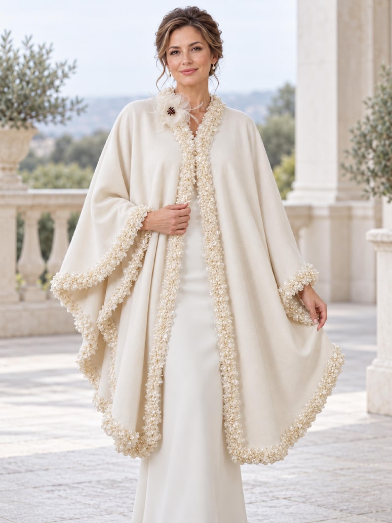 the model showcasing Front view of a luxury Ivory Bridal Cashmere Coat, Jacket with Lavish Trim, Couture Evening Cape, featuring a seamless circular cut, elegant drape, and one-size oversized silhouette.