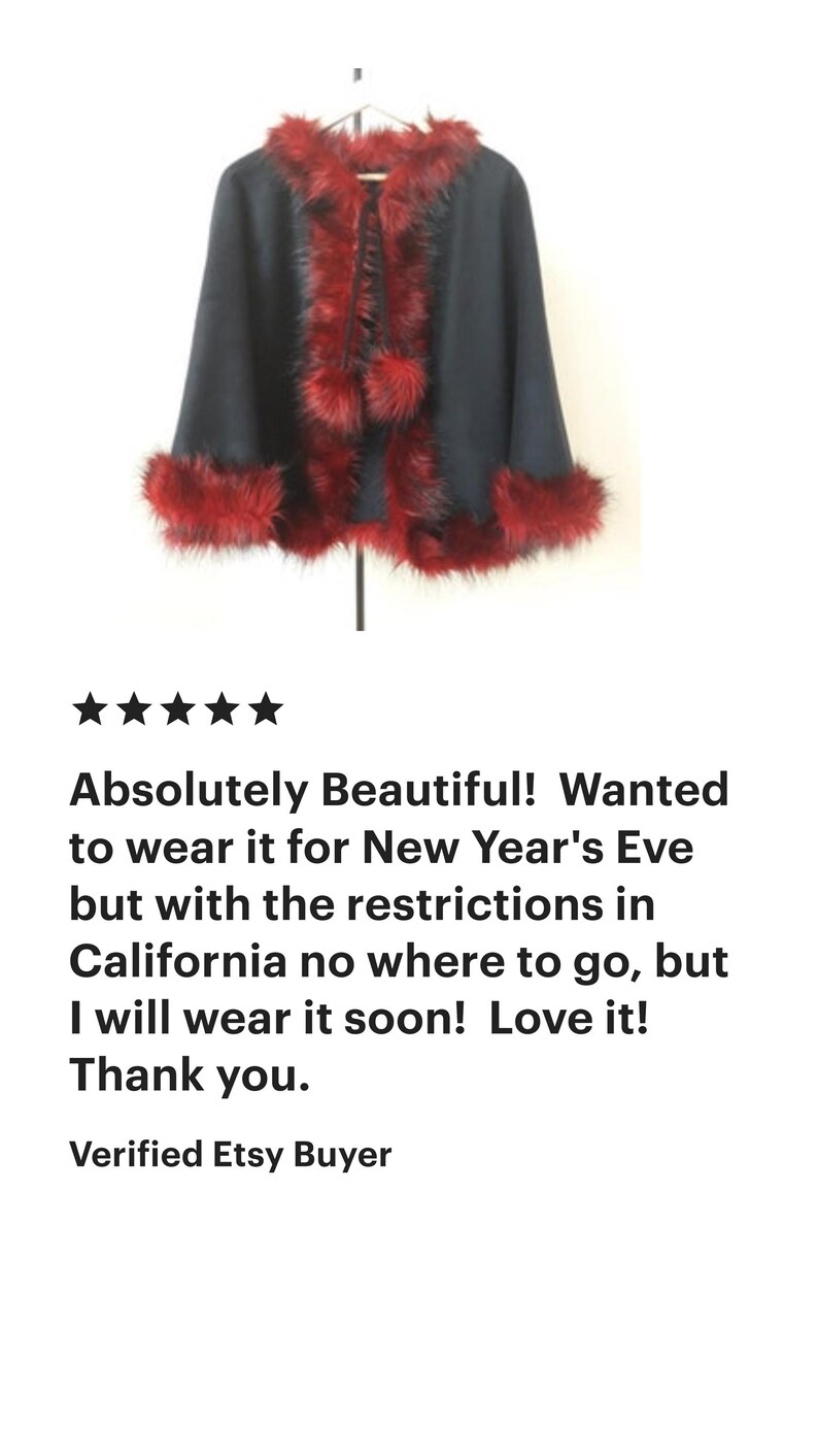 A black faux fur cape with a red faux fur trim and a pom-pom detail.  "Absolutely Beautiful! Wanted to wear it for New Year's Eve but with the restrictions in California no where to go, but I will wear it soon! Love it! Thank you. Verified Etsy Buyer"