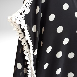 The photograph shows crochet embellishments on the sleeves and shoulders.