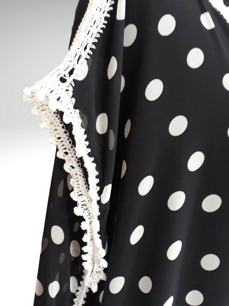 The photograph shows crochet embellishments on the sleeves and shoulders.