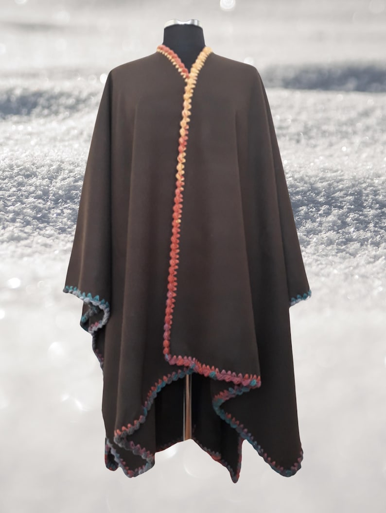 Front view of handmade baby alpaca ruana poncho featuring vibrant crochet edging and elegant draped silhouette.