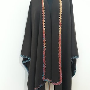 An open Front view of handmade baby alpaca ruana poncho featuring vibrant crochet edging and elegant draped silhouette.