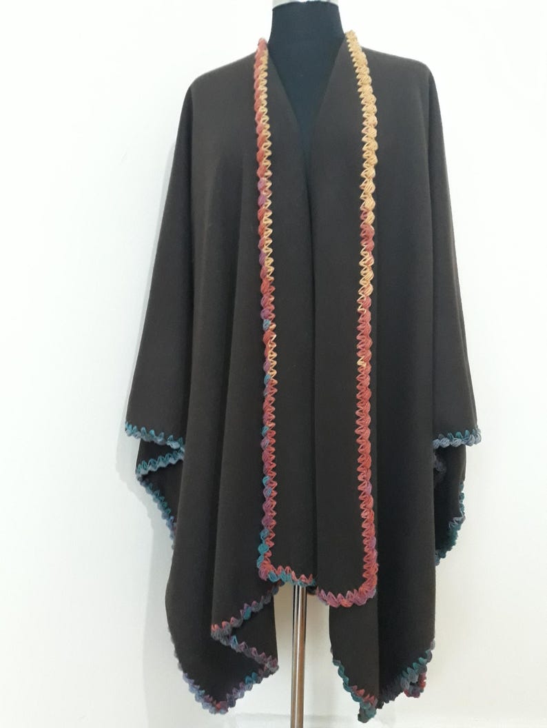 An open Front view of handmade baby alpaca ruana poncho featuring vibrant crochet edging and elegant draped silhouette.
