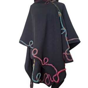 "Elegant handmade cashmere and wool ruana wrap, vintage inspired plus size cape poncho, decorated with colorful rainbow Romanian cord embroidery, photographed in natural outdoor light."