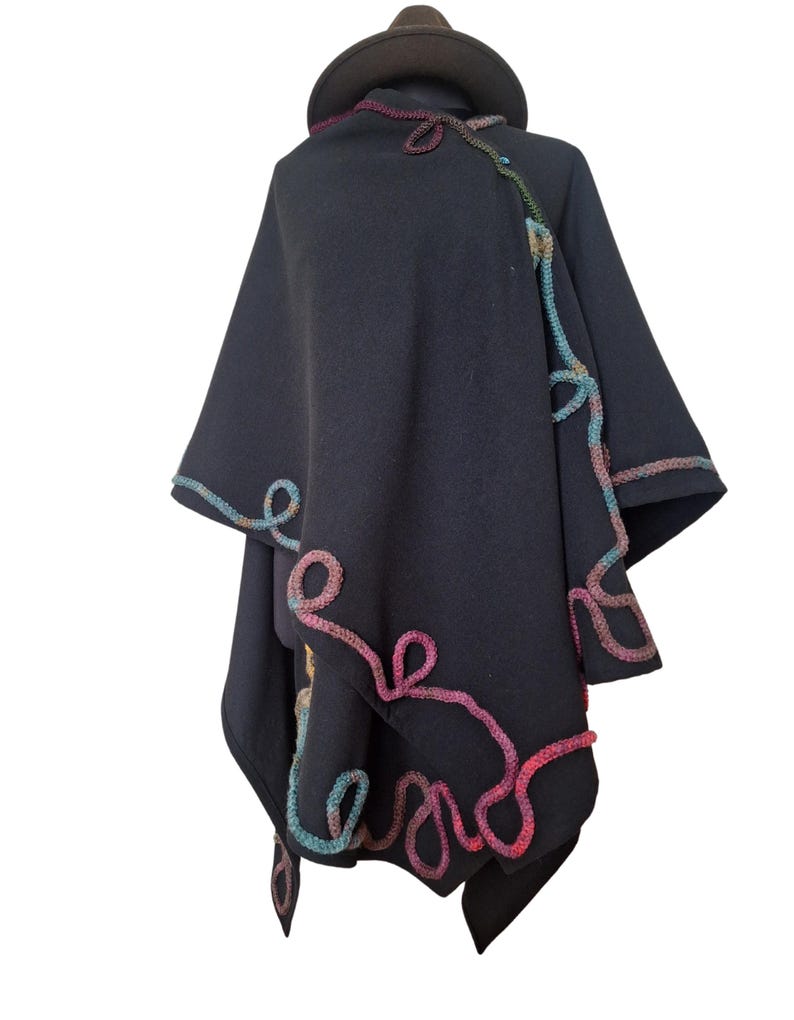 "Elegant handmade cashmere and wool ruana wrap, vintage inspired plus size cape poncho, decorated with colorful rainbow Romanian cord embroidery, photographed in natural outdoor light."