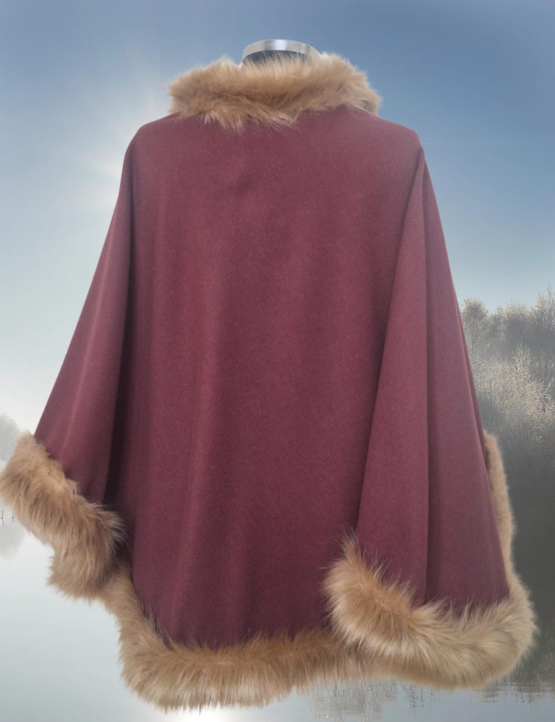 May include: A burgundy poncho with a faux fur collar and trim. The poncho is made of a soft, warm fabric and is perfect for cold weather.