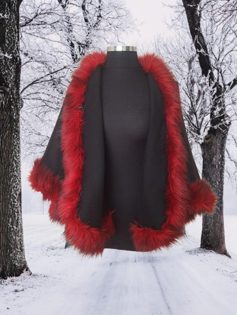 A inside  view of the Alpaca short cape with red fur trim on a black mannequin in a snowy forest