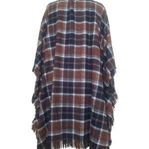 K&ouml;nnte beinhalten: Ein braunes, blaues und wei&szlig;es kariertes Poncho mit Fransenbesatz.