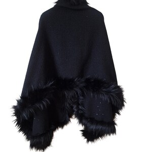 Back view of a handcrafted heavy wool tweed cape trimmed with soft black  fur, showing its full flowing drape and shimmering sequin details.”