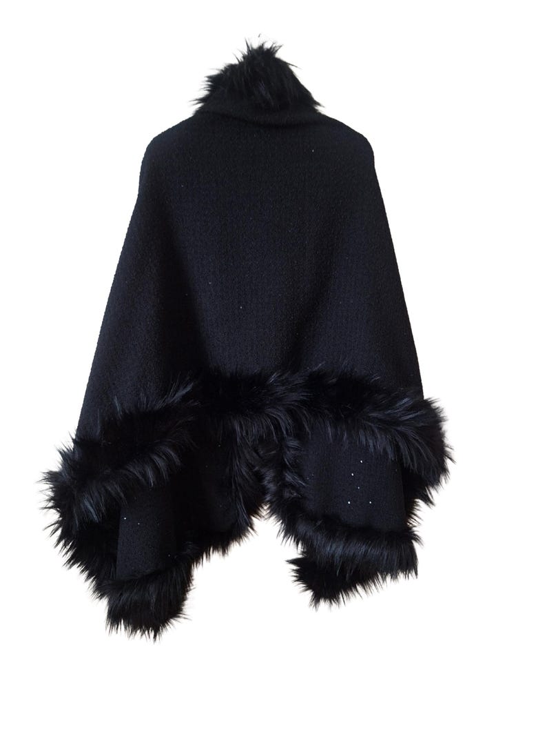 Back view of a handcrafted heavy wool tweed cape trimmed with soft black  fur, showing its full flowing drape and shimmering sequin details.”