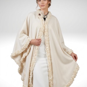 the model showcasing Front view of a luxury Ivory Bridal Cashmere Coat, Jacket with Lavish Trim, Couture Evening Cape, featuring a seamless circular cut, elegant drape, and one-size oversized silhouette.