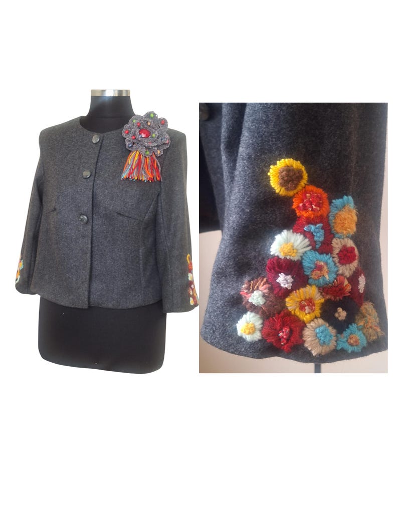 May include: A gray wool jacket with colorful embroidered flowers on the sleeves and a decorative brooch on the front.