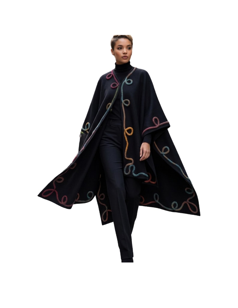 A live  fashion model wearing cashmere long cape poncho with colorful artisan handmade cord embellishments along the edges