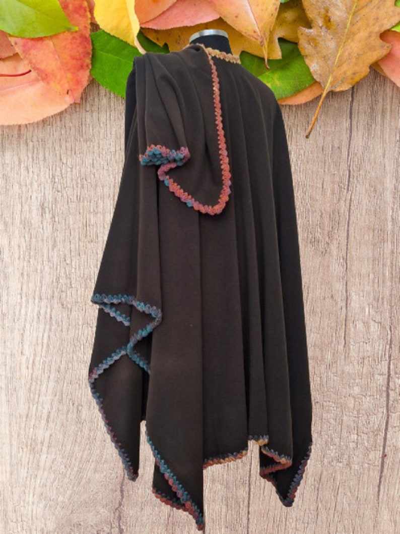 Alpaca Reversible ruana  with a multi-colored crocheted trim. The cape is displayed on a mannequin throwed one sides over the shoulder for a more romantic or dramatic wrap.