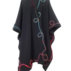 The open-front cape  displayed on a black mannequin, showcasing its handmade texture and design.