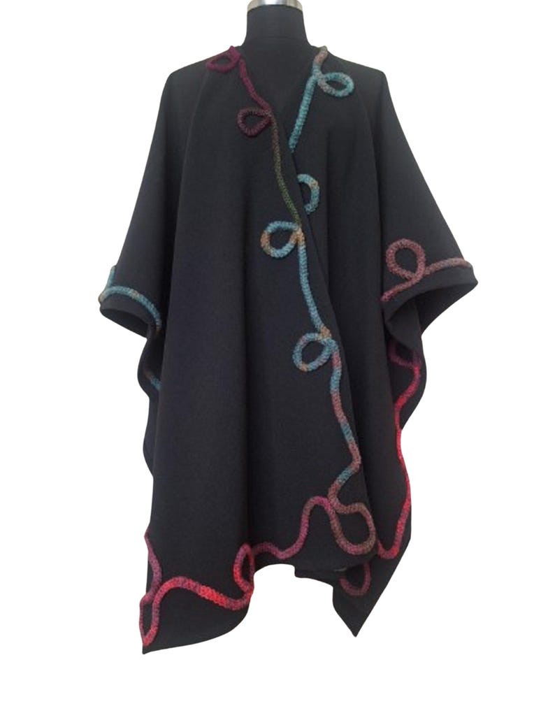 The open-front cape  displayed on a black mannequin, showcasing its handmade texture and design.